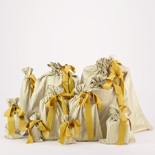Set of gift bags with striped patterns and yellow ribbons on a white background