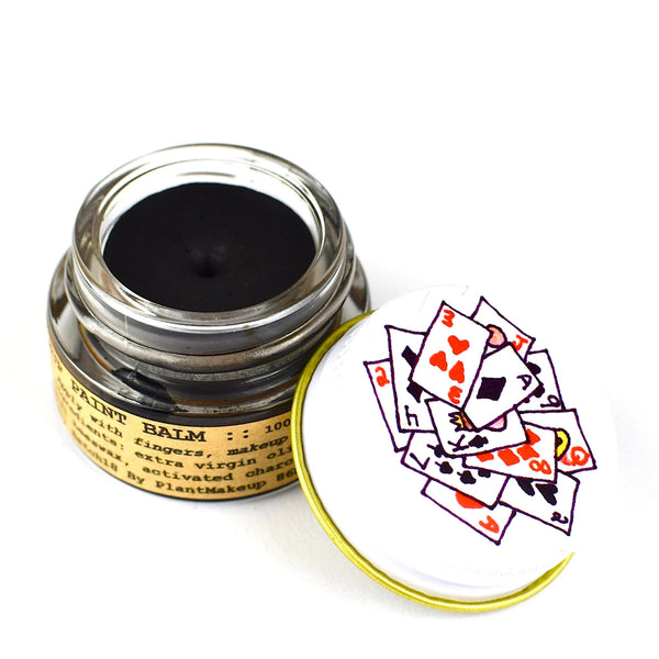 Jar of balm with a deck of cards on the lid against a white background