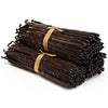 Stack of vanilla beans tied with a yellow ribbon on a white background