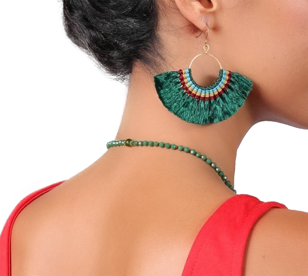 Green beaded earring and necklace on a person with a white background