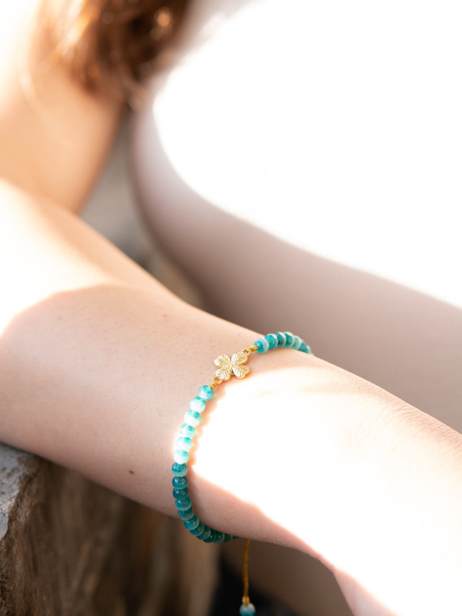 Close-up of green woven clover bracelet with recycled glass beads by Fair Anita