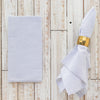 Folded striped napkin with a gold napkin ring on a wooden surface
