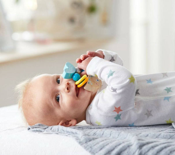 Close-up of HABA Rattlefish baby rattle showing beech wood construction and plastic rattle rings