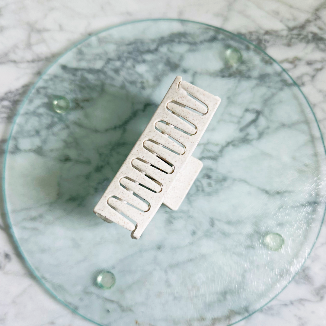 Metallic grill on a round glass plate with a marble background