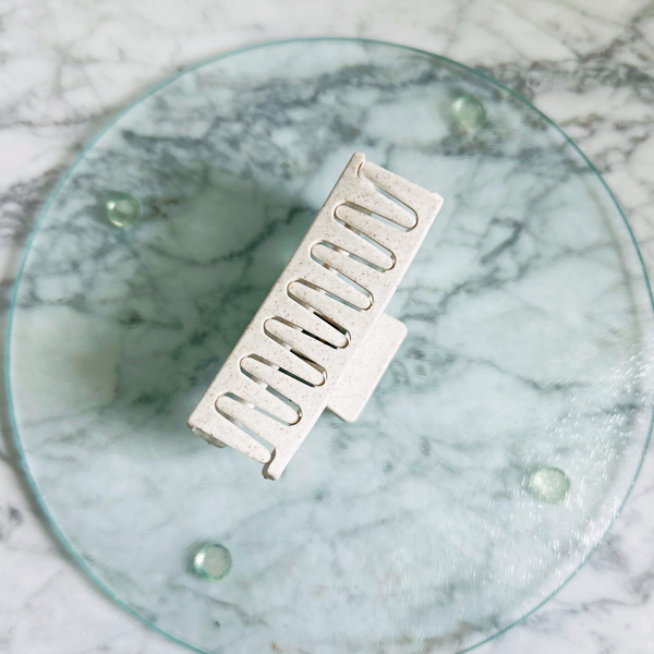 Metallic grill on a round glass plate with a marble background
