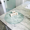 Glass tray with a white hair clip on a marble countertop