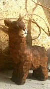 Wooden llama figure against a textured wall