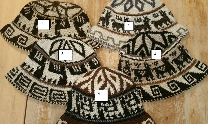 Five knitted hats with geometric patterns on a wooden surface