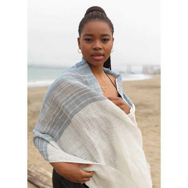 Woman wrapped in a light linen scarf on a beach