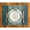 Set table with white plates, silverware, and a glass on a blue placemat.