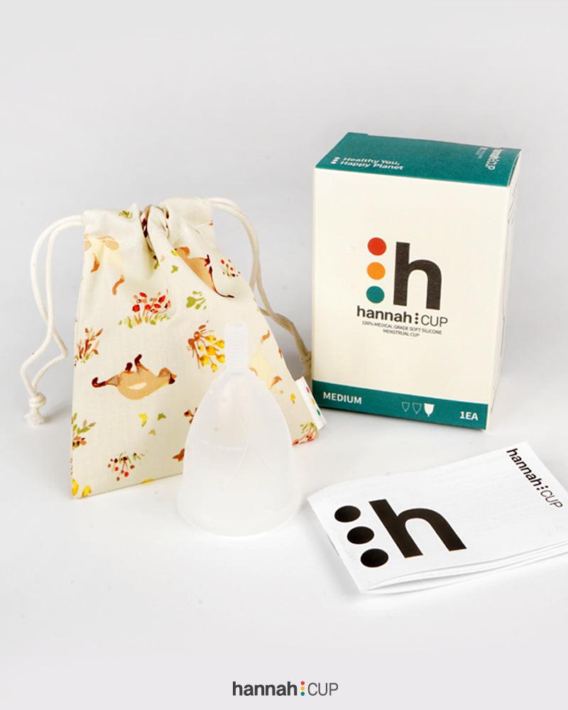 hannahCUP Medium menstrual cup shown with carry pouch and instruction booklet