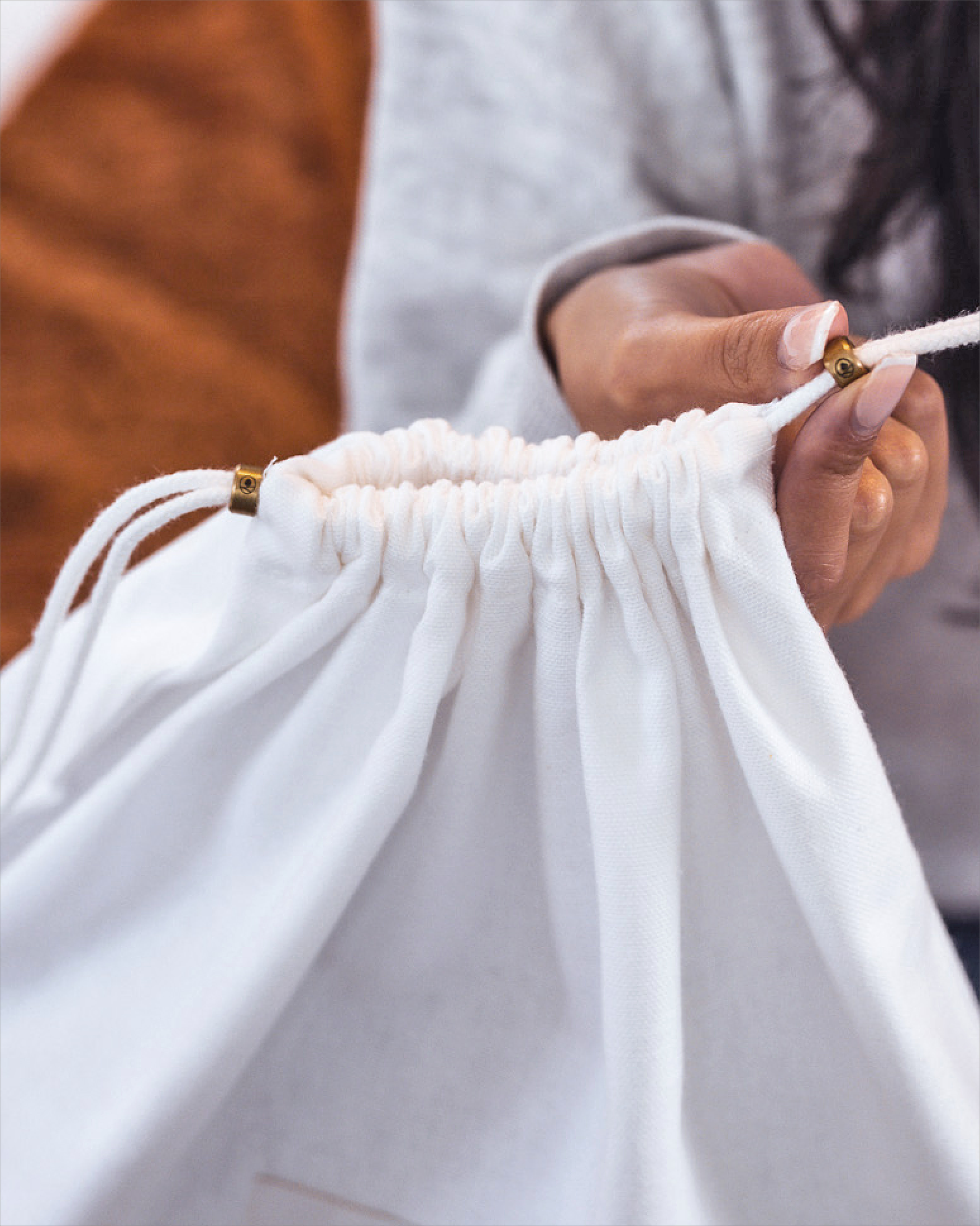 Close-up of Hayden Hill branded brass slider and organic cotton drawstring on dust bag
