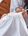 Close-up of Hayden Hill branded brass slider and organic cotton drawstring on dust bag