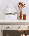 Medium organic cotton dust bag from Hayden Hill displayed on a dresser with dried flowers and candle