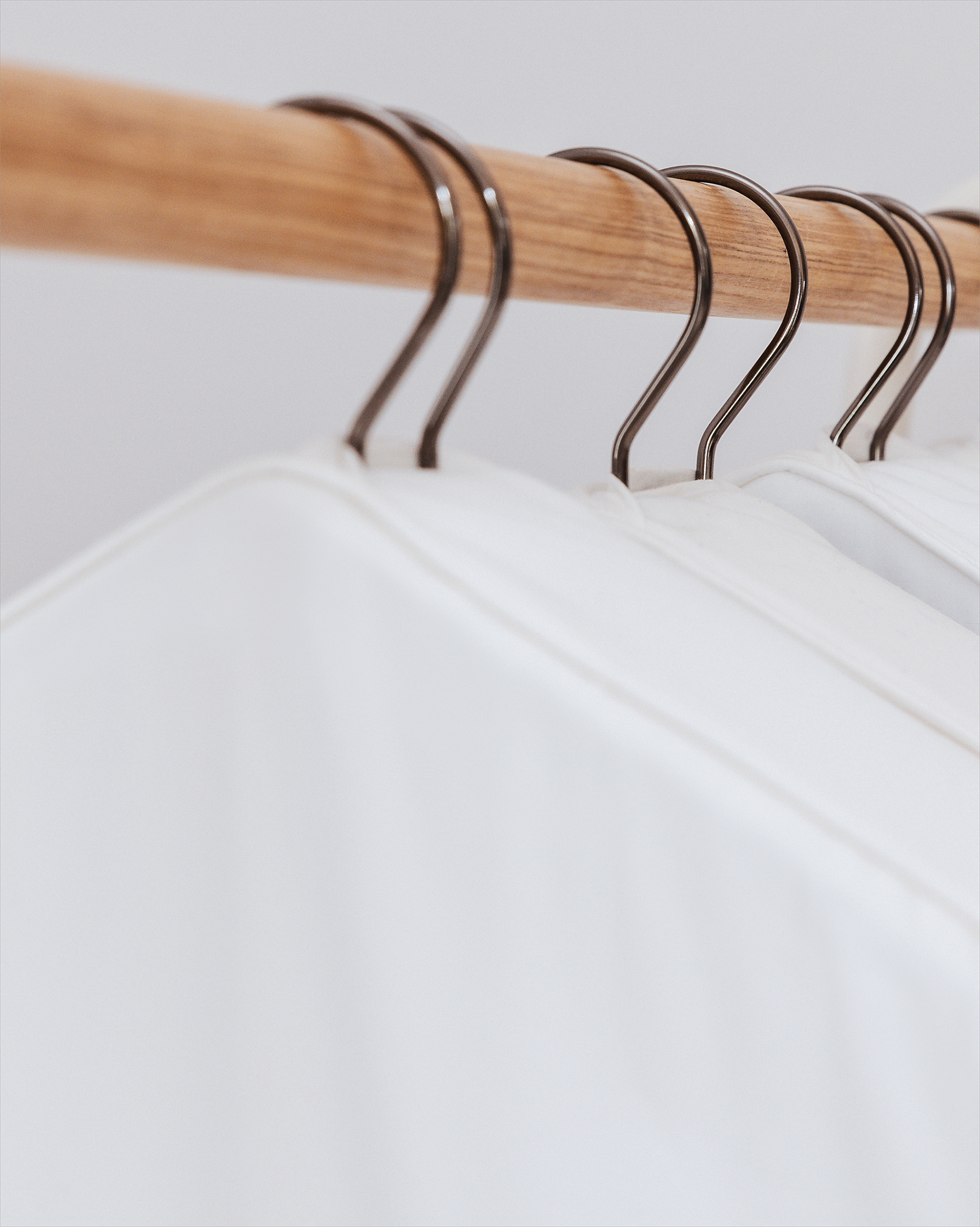 Wooden hanger with metal hooks on a white background