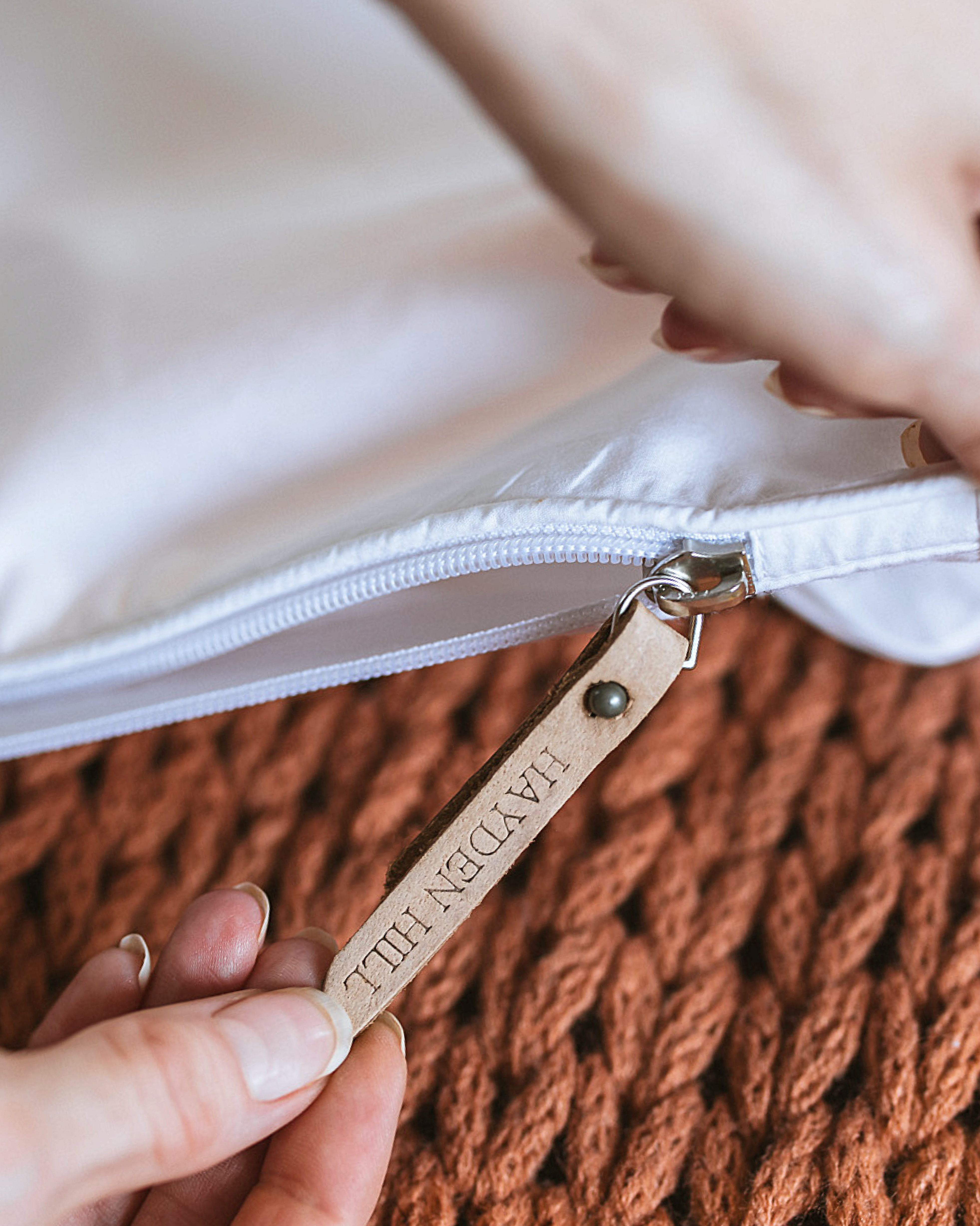 Close-up of zipper pull and tag detail on Hayden Hill short hanging garment bag