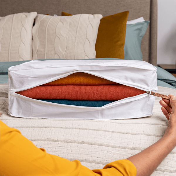 Woman unzipping an extra large organic cotton storage bag to access folded clothes