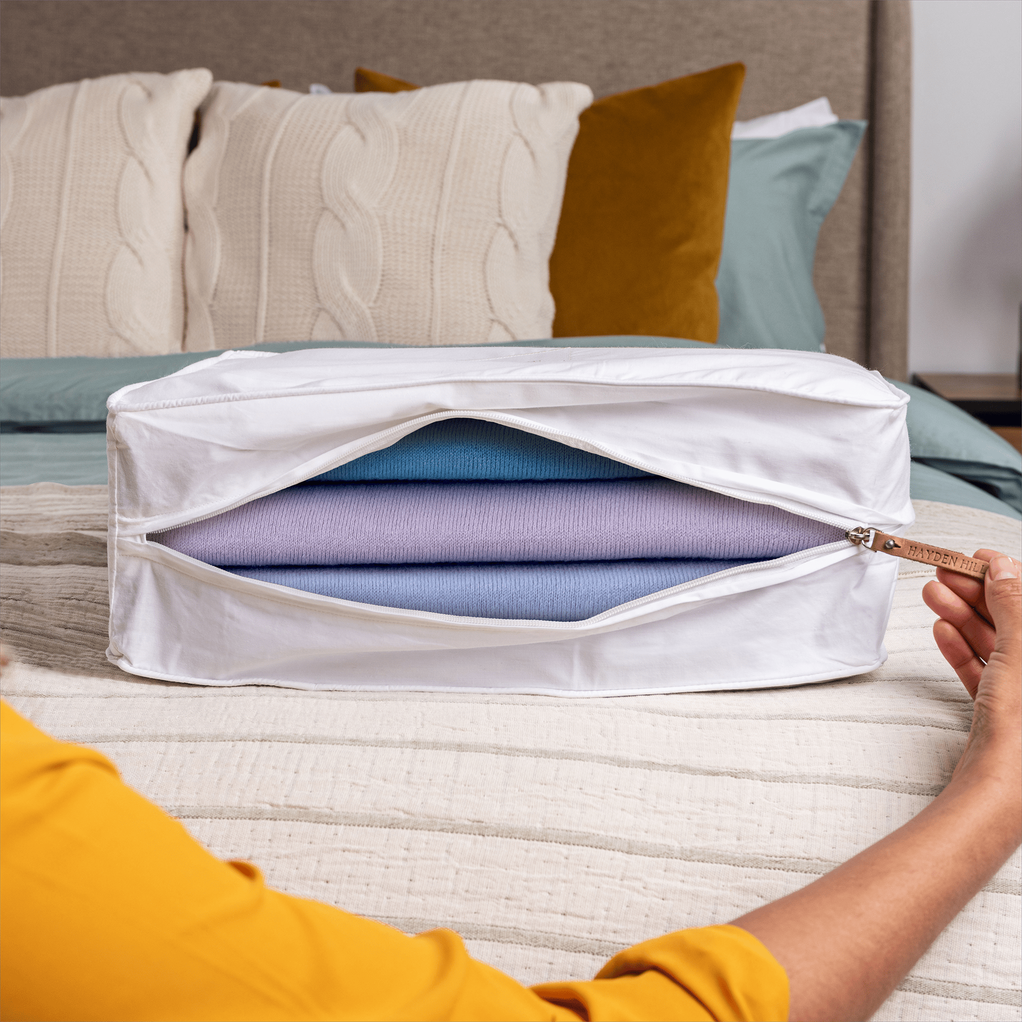 Woman unzipping a large organic cotton storage bag for clothes and linens