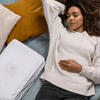 Close-up of large organic cotton storage bag with piping detail laying on bed
