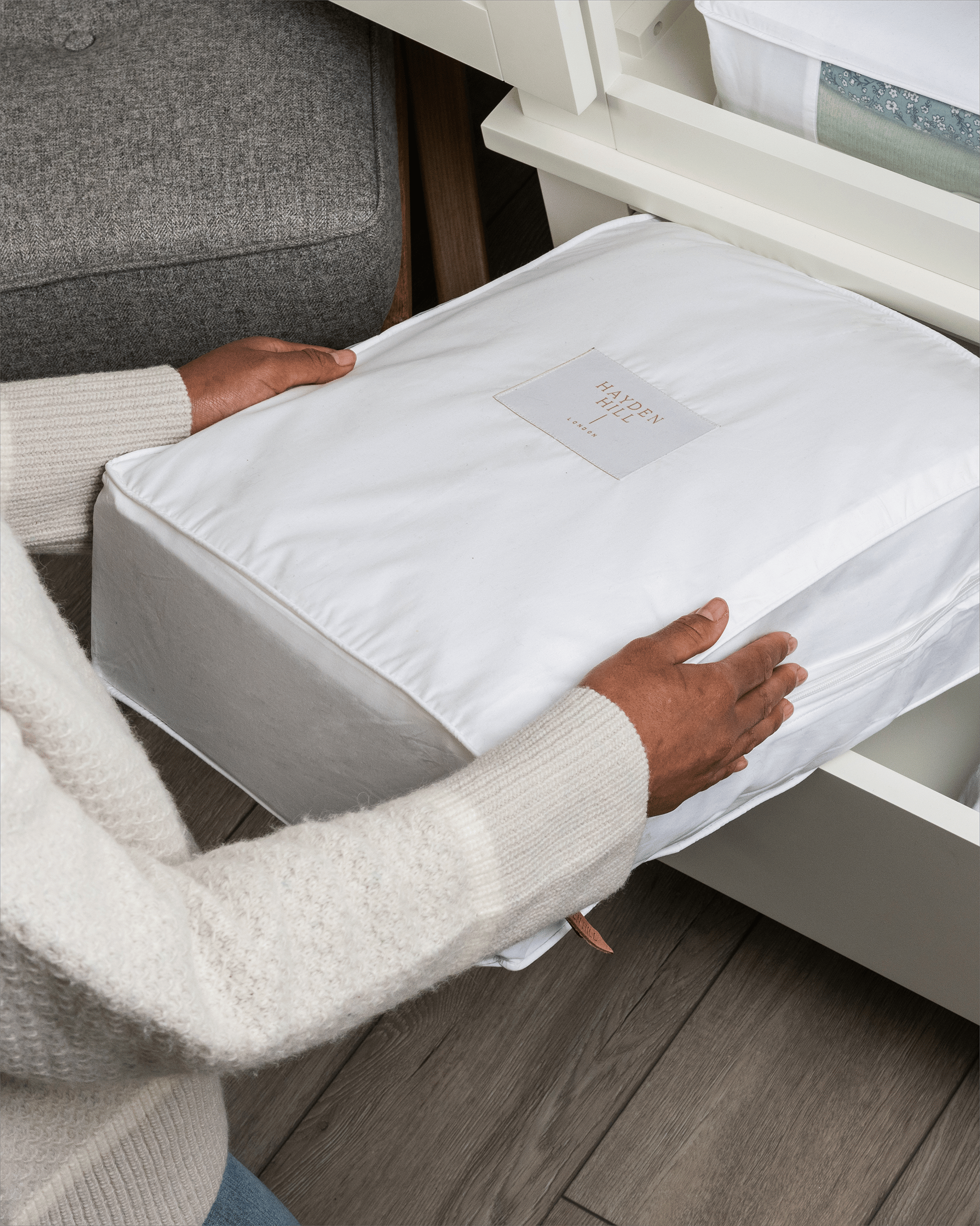 Woman placing an extra large organic cotton storage bag into a dresser drawer