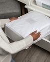 Woman placing an extra large organic cotton storage bag into a dresser drawer