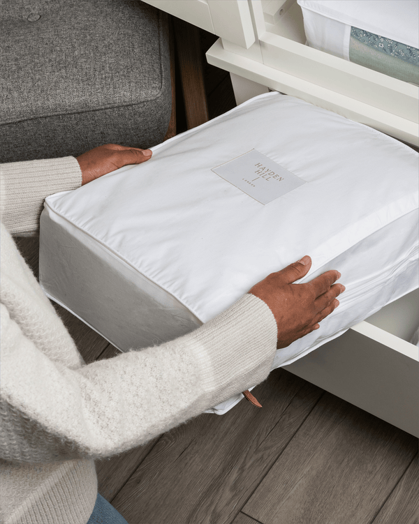Woman placing an extra large organic cotton storage bag into a dresser drawer