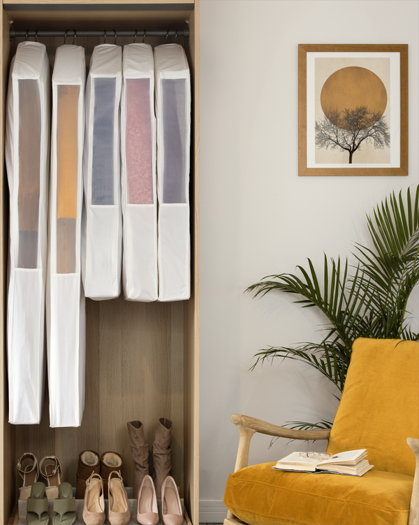 Coordinated wardrobe with long organic cotton hanging garment bags on a clothing rail