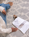 Woman holding a small Hayden Hill organic cotton dust bag on a rug — set of 3 for shoes and purses