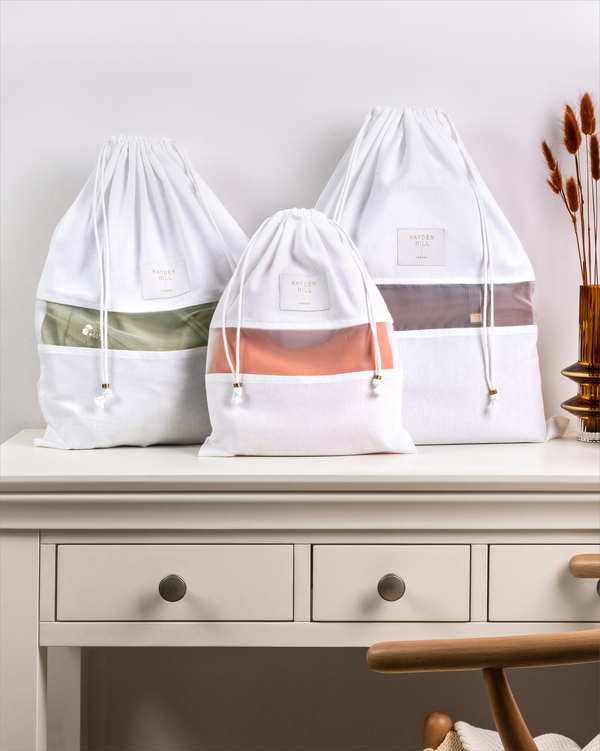 Set of three Hayden Hill organic cotton dust bags displayed on a dresser in small, medium and large sizes