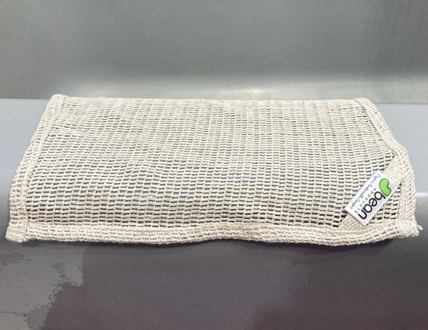 Mesh bag with a brand label on a gray surface