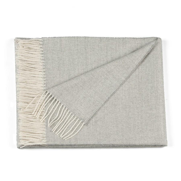 Herringbone baby alpaca throw blanket in a classic woven pattern, draped naturally to show texture and colour