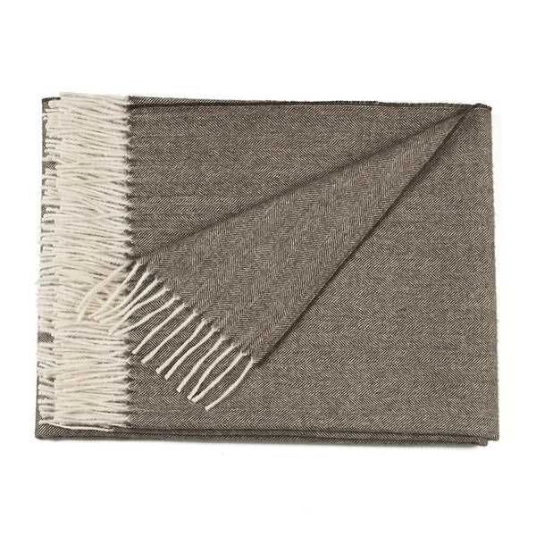 Soft baby alpaca herringbone throw blanket folded and styled on a sofa as a cosy home accessory