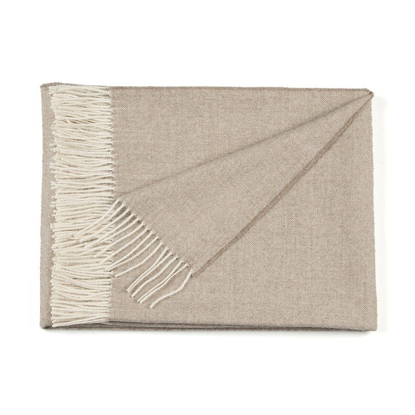 Beige throw blanket with white fringe on a white background