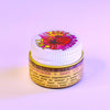 Jar of lip balm with colorful label on a light purple background