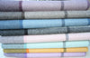 Stack of folded fabric swatches with plaid patterns in various colors.