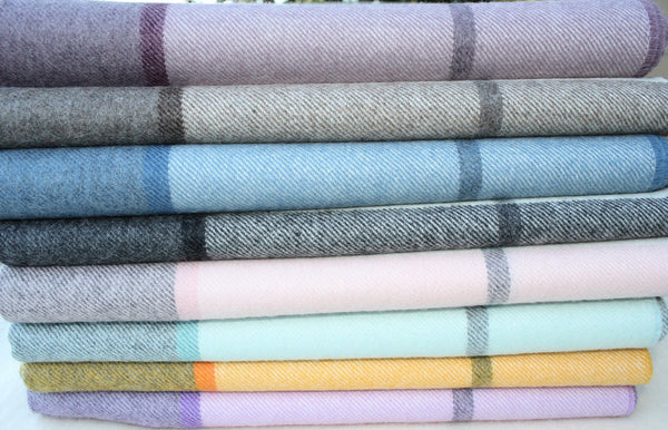 Stack of folded fabric swatches with plaid patterns in various colors.