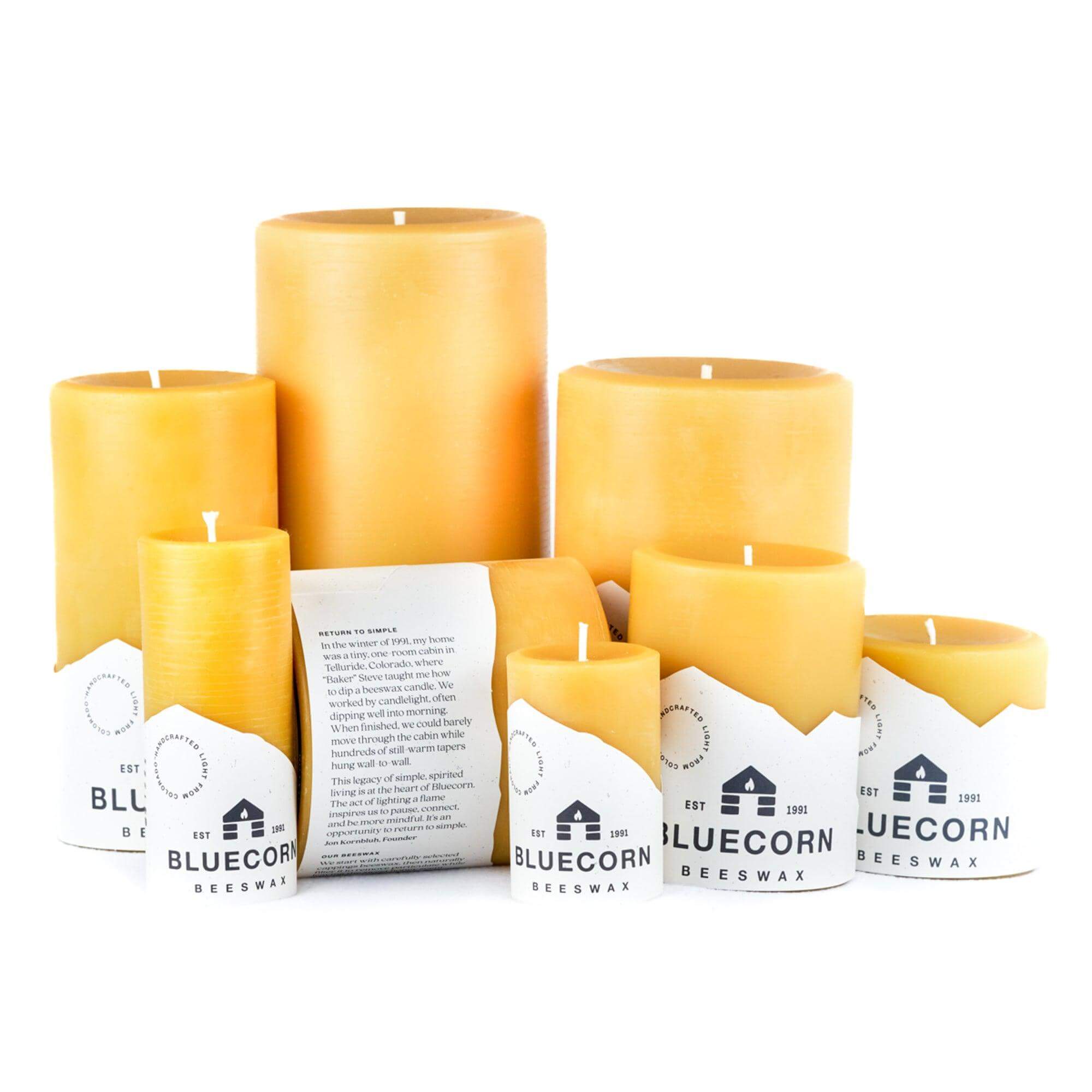Collection of beeswax candles with Bluecorn branding on a white background