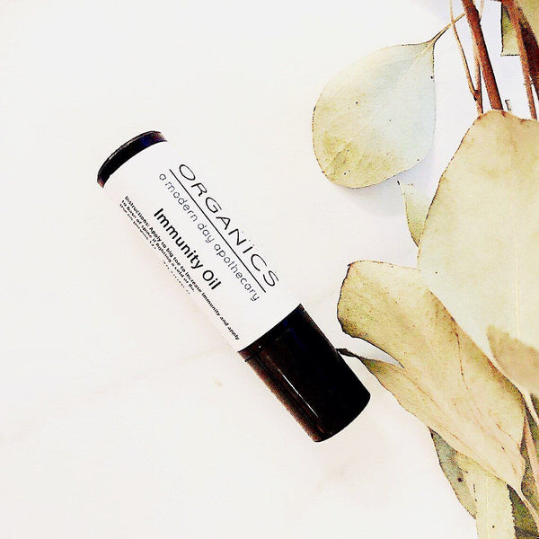 Organics Immunity Oil bottle with eucalyptus leaves on a white background