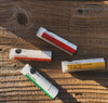 Heliotrope SF lip balm in hand showing portable 0.15 oz size for everyday use