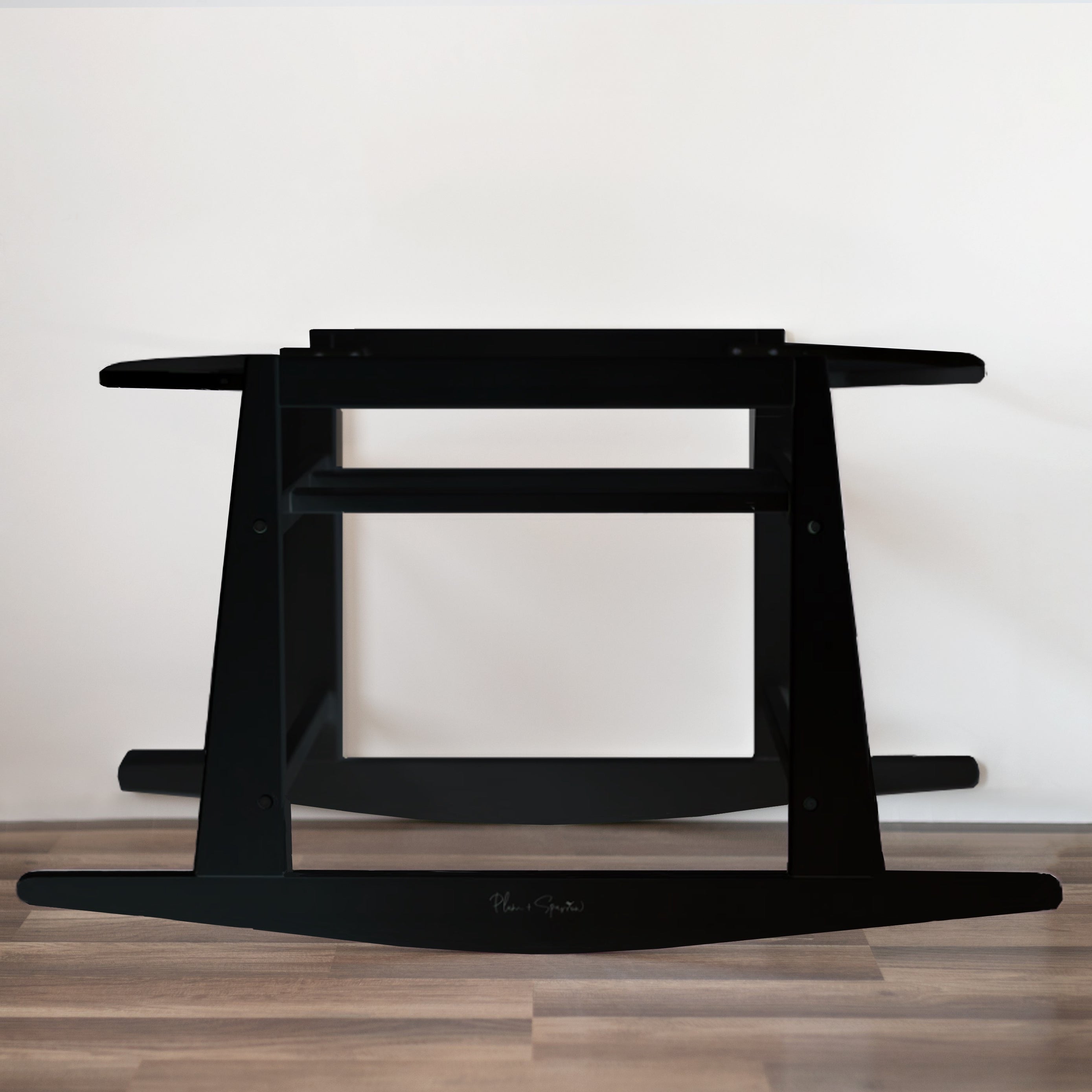 Plum+Sparrow black painted pine wood rocking Moses bassinet stand with brake on a light nursery floor