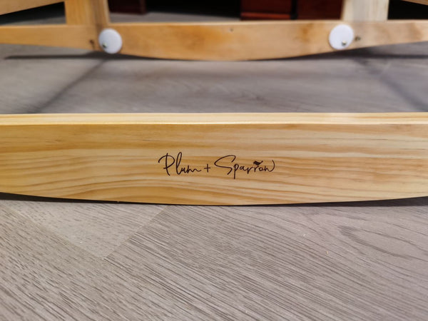 Wooden product with 'Plum + Sparrow' branding on a wooden surface.