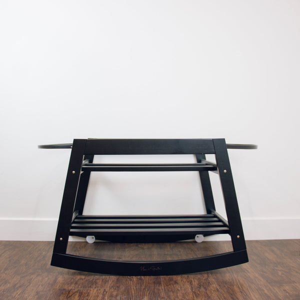Plum+Sparrow black rocking Moses basket stand displayed with Moses basket in a nursery setting