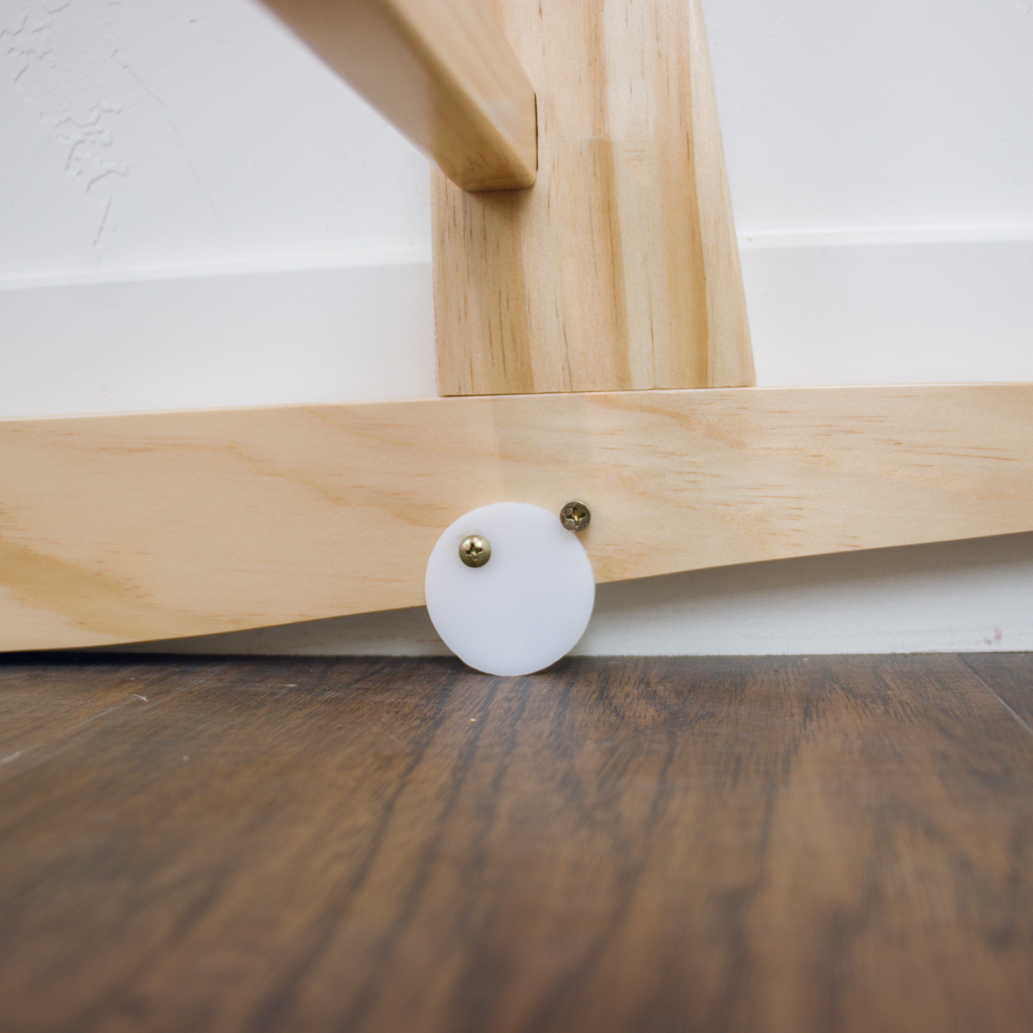 Detail view of adjustable straps on the Plum+Sparrow natural pine Moses basket stand