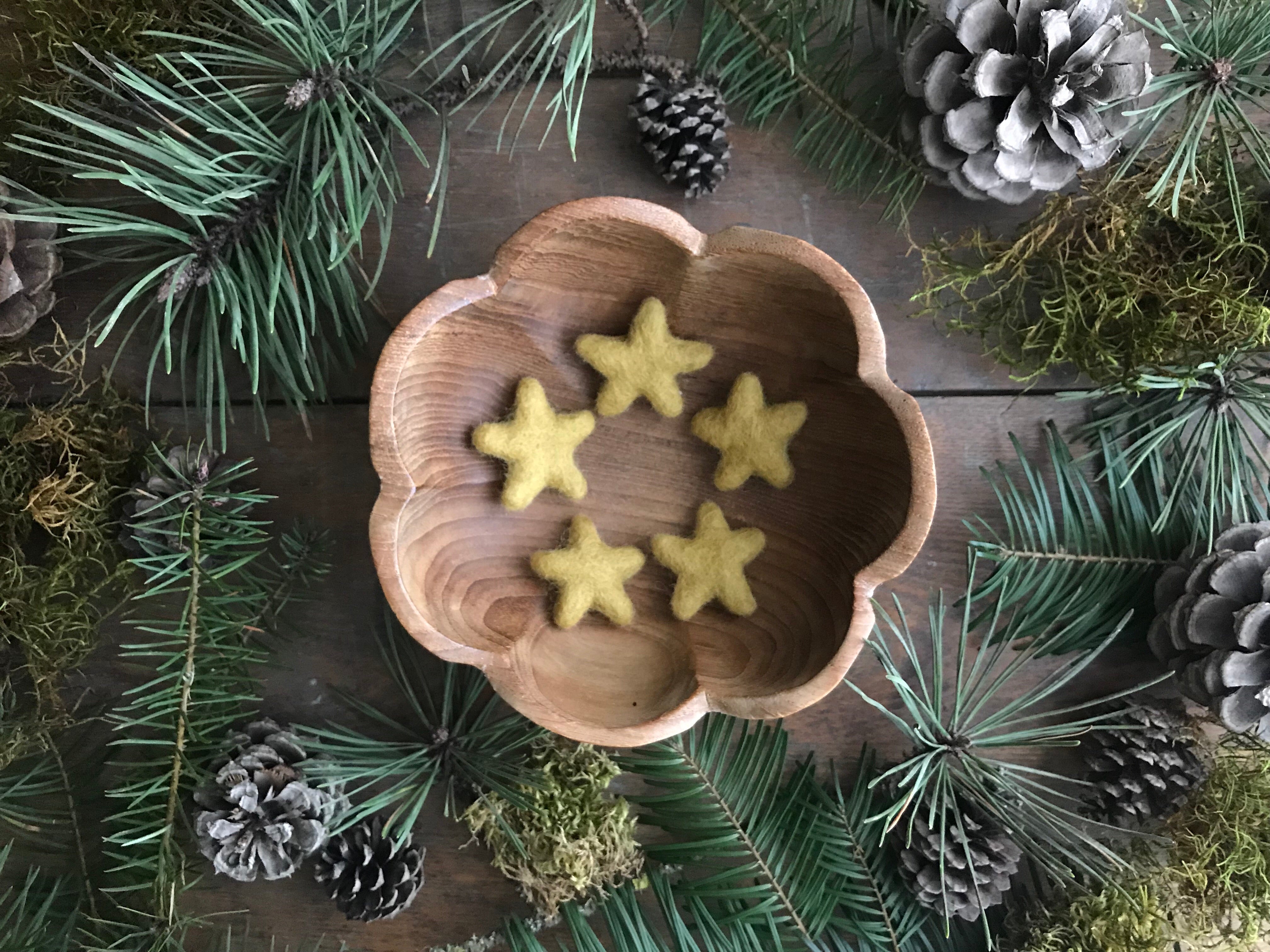 Handmade needle-felted wool stars in Gold Clay Yellow, each slightly different in size