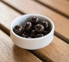 White bowl filled with dark chocolate chips on a wooden surface