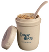 Beige ceramic cup with oatmeal and a spoon, featuring 'Dolly Oats' branding.