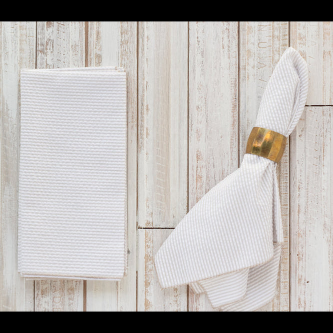 White textured towel with a gold ring on a wooden surface