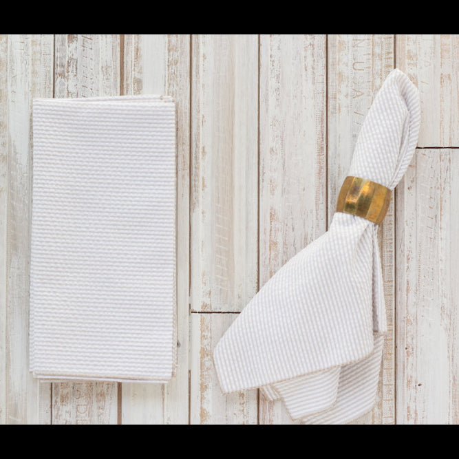White textured towel with a gold ring on a wooden surface