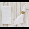 White textured towel with a gold ring on a wooden surface