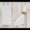 White textured towel with a gold ring on a wooden surface